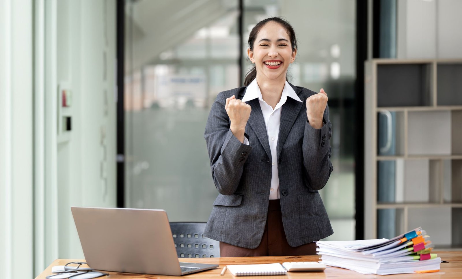 excited-businesswoman-standing-at-her-desk-office-2024-12-08-05-25-28-utc.jpg